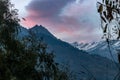 Cinematic shot of snowcap mountaintops against pink cloudy sunset sky in Himachal Pradesh, India