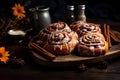 Cinnabon Buns with glaze on wooden background, autumn leaves