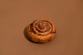 Cinnabon with cinnamon on a brown background