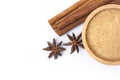 Cinnamon powder in wooden bowl and cinamon sticks with star anise isolated on white background. Royalty Free Stock Photo