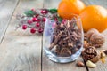 Cinnamon and anise in glass, oranges and nuts on background