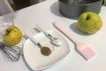 Cinnamon and baking powder in teaspoons. On the table are ingredients and tools for making charlotte. Autumn pie with apples