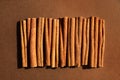 Cinnamon on brown background. Cassia sticks, alternative to real spice for dishes, coffee, cocoa. Monochrome chocolate color.