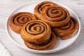 Cinnamon bun in white plate on white table Royalty Free Stock Photo