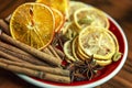 Cinnamon, cardamom, dry orange slices on a plate. Close-up. A set of spices to decorate dishes and drinks