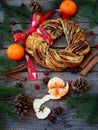 Cinnamon cocoa brown sugar wreath buns. Sweet Homemade christmas baking. Roll bread, tangerines, decoration on wooden background. Royalty Free Stock Photo