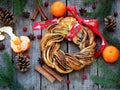 Cinnamon cocoa brown sugar wreath buns. Sweet Homemade christmas baking. Roll bread, tangerines, decoration on wooden background. Royalty Free Stock Photo