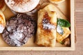 Cinnamon coffee in a disposable paper cup with a blank white card for the inscription. Cookies and apple strudel on a brown wooden