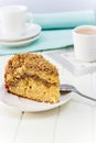 Cinnamon crumble coffee cake and cup of milk tea on white background