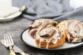 Cinnamon danish bun or cinnabons on dark background with coffee cup. Sweet homemade pastry