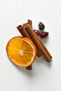 Cinnamon, dried orange and dried rose hips on a white background