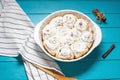 Cinnamon, homemade recipe of sweet traditional dessert buns with white cream sauce on blue wooden background Royalty Free Stock Photo