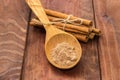 Cinnamon powder in spoon and cinnamon sticks on rustic table Royalty Free Stock Photo