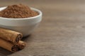 Cinnamon powder and sticks on wooden table, closeup. Space for text Royalty Free Stock Photo