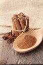 Cinnamon powder on wooden spoon and bunch of cinnamon sticks Royalty Free Stock Photo