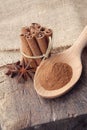 Cinnamon powder on wooden spoon and bunch of cinnamon sticks Royalty Free Stock Photo