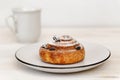 Cinnamon roll with raisins in a ceramic saucer Royalty Free Stock Photo