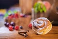 Cinnamon roll with cinnamon sticks and berries