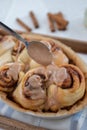 Cinnamon rolls with sugar frosting. With cinnamon sticks and spices, wooden background Royalty Free Stock Photo