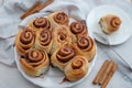 Cinnamon rolls with sugar frosting. With cinnamon sticks and spices, wooden background Royalty Free Stock Photo