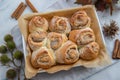 Cinnamon rolls with sugar frosting. With cinnamon sticks and spices, wooden background Royalty Free Stock Photo