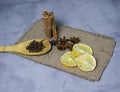 Cinnamon star anise and cloves dried lemon are scattered on the matting