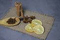 Cinnamon star anise and cloves dried lemon are scattered on a brown napkin