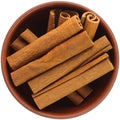 Cinnamon stick in a brown ceramic bowl isolated on white background. Isolated close-up photo of food close up from above on white Royalty Free Stock Photo