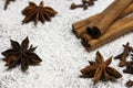 Cinnamon sticks and anise stars closeup on powdered sugar table. Cooking and baking background. Aromatic condiment and spices. Royalty Free Stock Photo