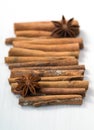 Cinnamon sticks and anise stars on white wooden background Royalty Free Stock Photo