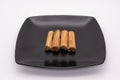 Cinnamon sticks on a black plate against a white background Royalty Free Stock Photo