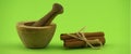 Cinnamon sticks bundle and wooden mortar with pestle Royalty Free Stock Photo