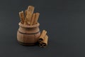 Cinnamon sticks bundle in wooden pot over black Royalty Free Stock Photo