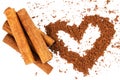 Cinnamon sticks and cacao powder in shape of heart, isolated on white background. Royalty Free Stock Photo