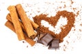 Cinnamon sticks, chocolate cubes and cacao powder in shape of heart, isolated on white background. Royalty Free Stock Photo