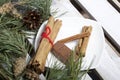 Cinnamon sticks and chocolate next to the pine twigs and cones. On a wooden box