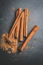 Cinnamon sticks with cinnamon powder on stone plate background Royalty Free Stock Photo