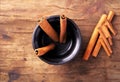 Cinnamon sticks in cup on old wooden background Royalty Free Stock Photo