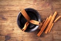 Cinnamon sticks in cup on old wooden background. Royalty Free Stock Photo