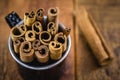 Cinnamon sticks isolated on background rustic wood inside black mug