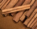 Cinnamon Sticks laying atop Ground Cinnamon with One Stick Askew