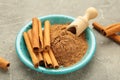 Cinnamon sticks and powder in blue bowl on grey background Royalty Free Stock Photo