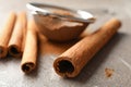 Cinnamon sticks, powder and sieve on grey background Royalty Free Stock Photo