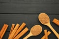 Cinnamon sticks and powder in wooden spoon on black wooden background Royalty Free Stock Photo