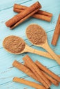 Cinnamon sticks and powder in wooden spoon on blue wooden background Royalty Free Stock Photo