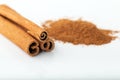 Cinnamon sticks with cinnamon powder in wooden spoon on white background Royalty Free Stock Photo