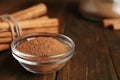 Cinnamon sticks and powder on wooden table, closeup. Space for text Royalty Free Stock Photo