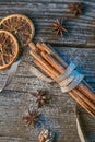 Cinnamon sticks with ribbon, spices and walnuts on wooden table, wishing merry christmas