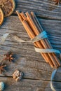 Cinnamon sticks with ribbon, spices and walnuts on wooden table, wishing merry christmas