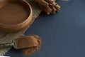 Cinnamon sticks, tied with jute rope in rustic style. Ground cinnamon in a wooden bowl and vintage scoop. Close up on a Royalty Free Stock Photo